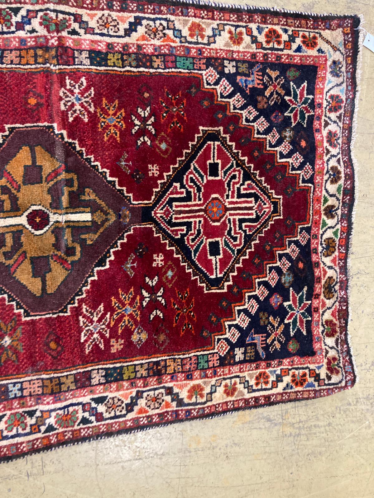A small Kasak rug with three medallions on a crimson ground, 148 x 95cm